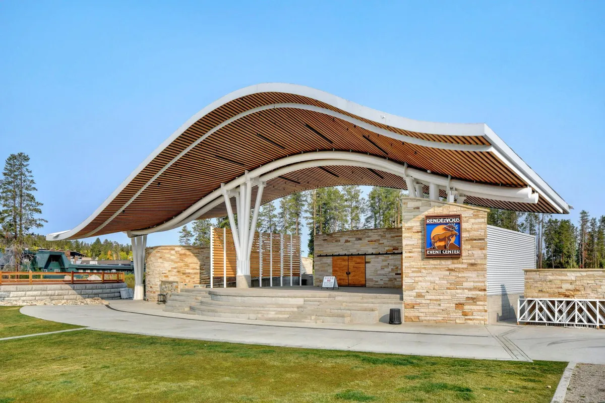 An inviting shot of the Hideaway Park amphitheater with its curved roof, stone façade, and open stage area, set up for outdoor concerts and community events, capturing the venue’s festive atmosphere.